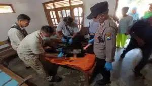 Petugas kepolisian bersama tim medis mengevakuasi jenazah pria berinisial B di rumah duka usai ditemukan meninggal di gubuk sawah wilayah Kanigoro, Blitar.