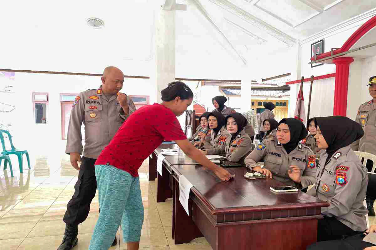 Petugas Polres Blitar melayani warga saat penyaluran beras SPHP dalam program Gerakan Pangan Murah di Kabupaten Blitar, Senin