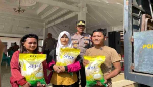 Warga penerima bantuan menunjukkan beras SPHP yang dibagikan Polres Blitar bekerja sama dengan Perum Bulog dalam program Gerakan Pangan Murah di Kabupaten Blitar, Senin (11/8/2025).