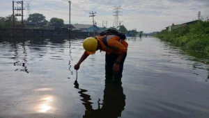 Petugas KAI memantau kondisi jalur rel yang tergenang air akibat banjir di wilayah Semarang, Rabu (29/10/2025).