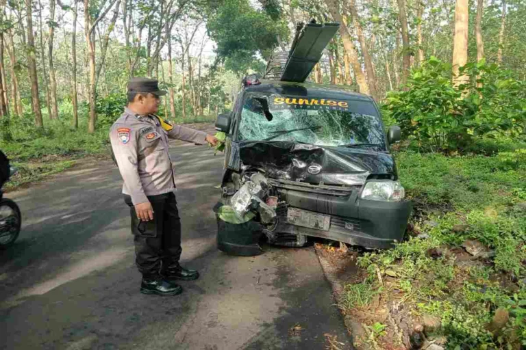 Polisi menunjuk bagian depan mobil pick up Daihatsu Grandmax yang ringsek usai terlibat tabrakan adu banteng dengan sepeda motor di Desa Kaulon, Kecamatan Sutojayan, Blitar, Kamis (2/10/2025) pagi.