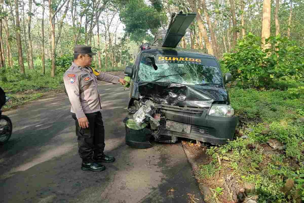Polisi menunjuk bagian depan mobil pick up Daihatsu Grandmax yang ringsek usai terlibat tabrakan adu banteng dengan sepeda motor di Desa Kaulon, Kecamatan Sutojayan, Blitar, Kamis (2/10/2025) pagi.