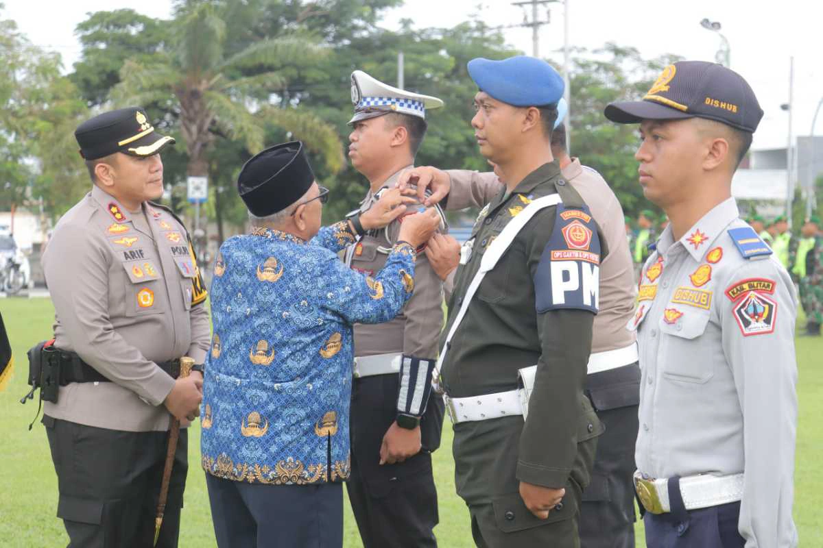Kapolres Blitar bersama Forkopimda menyematkan pita tanda dimulainya Operasi Zebra Semeru 2025 saat Apel Gelar Pasukan di Alun-Alun Blitar, Senin (17/11/2025).