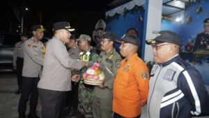 Kapolres Blitar AKBP Arif Fazlurrahman, S.H., S.I.K., M.Si. menyerahkan bingkisan sekaligus melakukan pengecekan kesiapsiagaan personel gabungan pada Pos Pengamanan Operasi Lilin Semeru 2025 di wilayah hukum Polres Blitar, Selasa (23/12/2025).