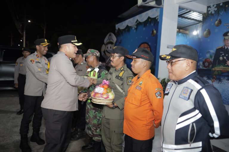 Kapolres Blitar AKBP Arif Fazlurrahman, S.H., S.I.K., M.Si. menyerahkan bingkisan sekaligus melakukan pengecekan kesiapsiagaan personel gabungan pada Pos Pengamanan Operasi Lilin Semeru 2025 di wilayah hukum Polres Blitar, Selasa (23/12/2025).