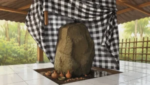 Ilustrasi batu punden yang dibalut kain poleng dan dikeramatkan warga setempat