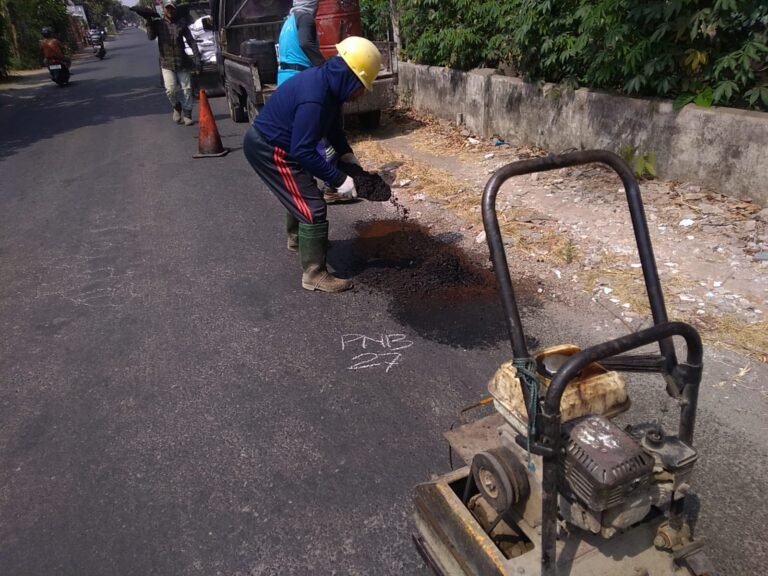 Petugas UPT PJJ Tulungagung melakukan pemeliharaan rutin dengan menambal kerusakan pada ruas jalan Plandaan–Boro, Minggu (28/9/2026).