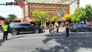 Petugas kepolisian bersama petugas keamanan melakukan pengamanan dan pengaturan arus lalu lintas di kawasan Kampung Coklat, Kabupaten Blitar, Minggu (13/9/2026).