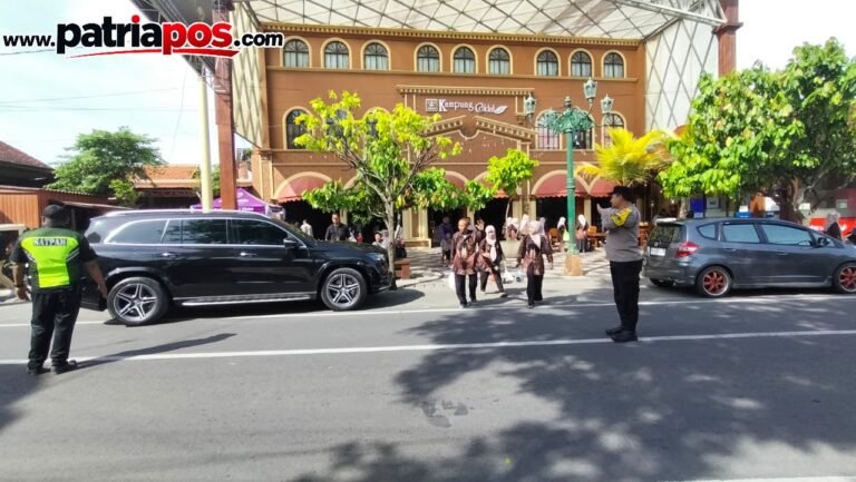 Petugas kepolisian bersama petugas keamanan melakukan pengamanan dan pengaturan arus lalu lintas di kawasan Kampung Coklat, Kabupaten Blitar, Minggu (13/9/2026).