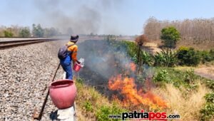 Petugas KAI memadamkan api di sekitar jalur kereta api yang terbakar akibat pembakaran lahan dan ilalang.