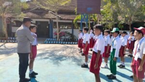Bhabinkamtibmas Desa Kaligambir saat memberikan pembinaan kepada para siswa dalam kegiatan Police Goes to School di SDN 01 Kaligambir, Kecamatan Panggungrejo, Kabupaten Blitar, Senin (28/9/2026).