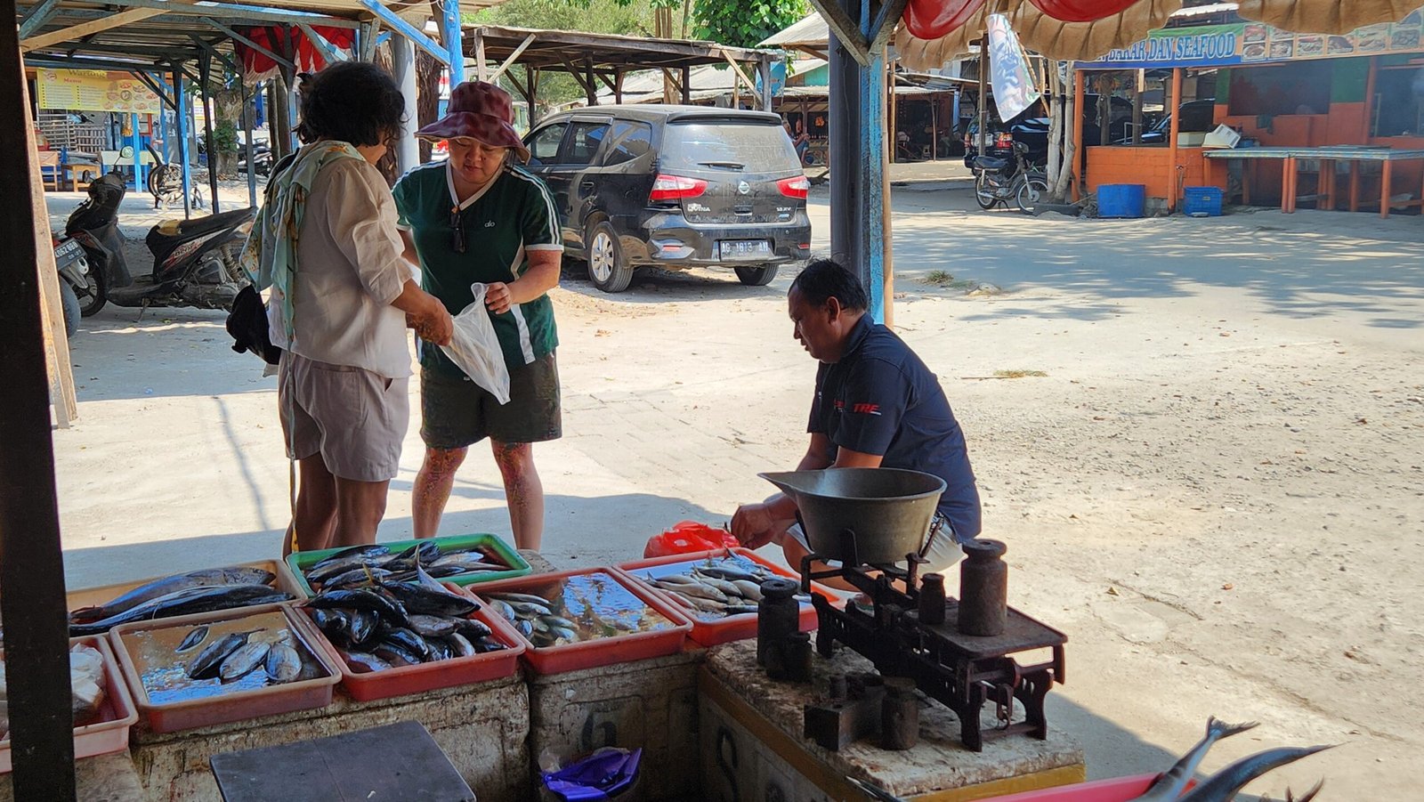 Aktifitas pedagang menjajakan beragam hasil laut, mulai dari ikan hingga aneka komoditas laut lainnya, kepada wisatawan di kawasan Pantai Tambakrejo, Kabupaten Blitar.