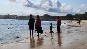 Sejumlah wisatawan menikmati suasana dan panorama laut bersama keluarga di tepi Pantai Tambakrejo, Kecamatan Wonotirto, Kabupaten Blitar, Jumat (9/10/2026).