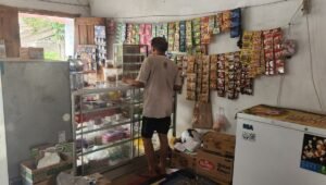 Ilustrasi pemilik warung kelontong yang bersiap membuka usaha.