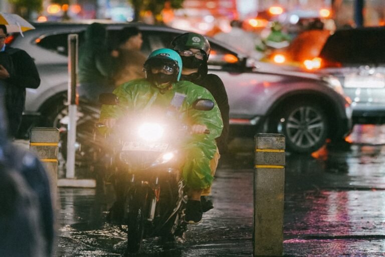 Pengendara sepeda motor melintasi jalan basah saat hujan, ilustrasi prakiraan cuaca Jawa Timur 27 Oktober 2026.