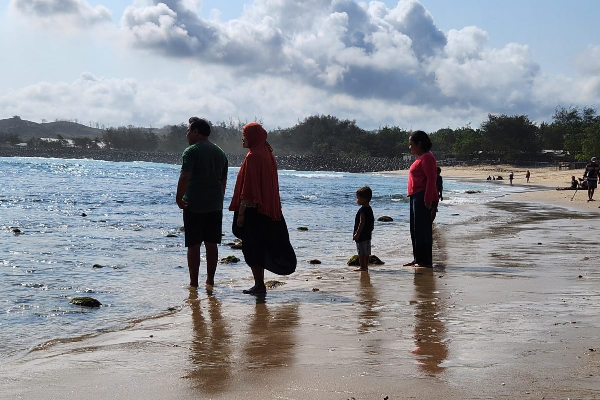 Sejumlah wisatawan menikmati suasana dan panorama laut bersama keluarga di tepi Pantai Tambakrejo, Kecamatan Wonotirto, Kabupaten Blitar, Jumat (9/10/2026).