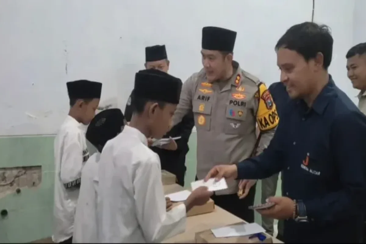 Caption Ketua IJTI Korda Blitar, Roby, bersama Kapolres Blitar, AKBP Arif Fazlurahman, menyalurkan santunan kepada puluhan anak yatim di Kanigoro.