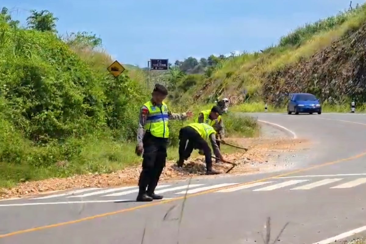 IMG-20250411-WA0005 Caption Sejumlah anggota Polres Blitar melakukan aksi sigap dengan membersihkan material longsor berupa tanah dan batu kerikil yang menutupi sebagian badan Jalan Lintas Selatan