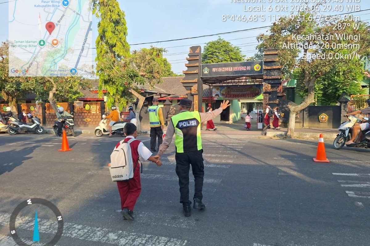 Anggota Polsek Wlingi membantu menyeberangkan pelajar saat melaksanakan strong point pagi di depan SDN Babadan 01, Wlingi, Blitar, Selasa (6/10/2026). Anggota Polsek Wlingi membantu menyeberangkan pelajar saat melaksanakan strong point pagi di depan SDN Babadan 01, Wlingi, Blitar, Selasa (6/10/2026).