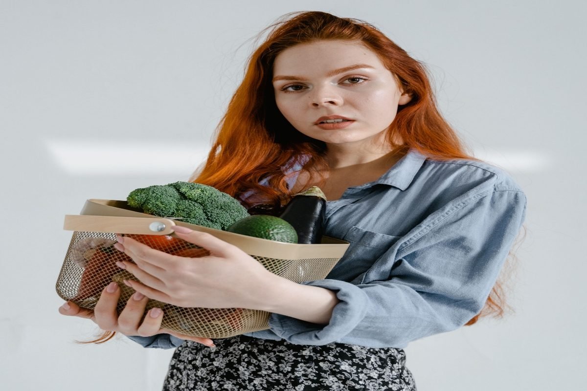 Seorang perempuan memegang buah dan sayuran segar sebagai bagian dari pola makan sehat untuk mendukung kesehatan kulit. Seorang perempuan memegang buah dan sayuran segar sebagai bagian dari pola makan sehat untuk mendukung kesehatan kulit.
