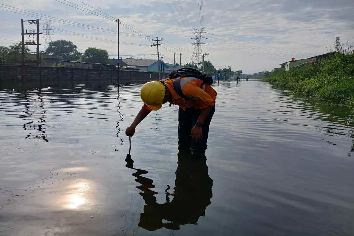 Petugas KAI memantau kondisi jalur rel yang tergenang air akibat banjir di wilayah Semarang, Rabu (29/10/2025).